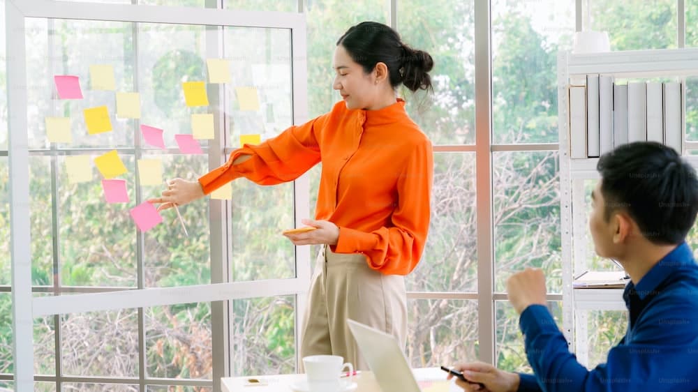 Business people work on project planning board in office